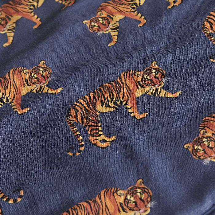 Nahaufnahme eines dunkelblauen Baumwollstoffs mit wiederholtem Tiger-Motiv