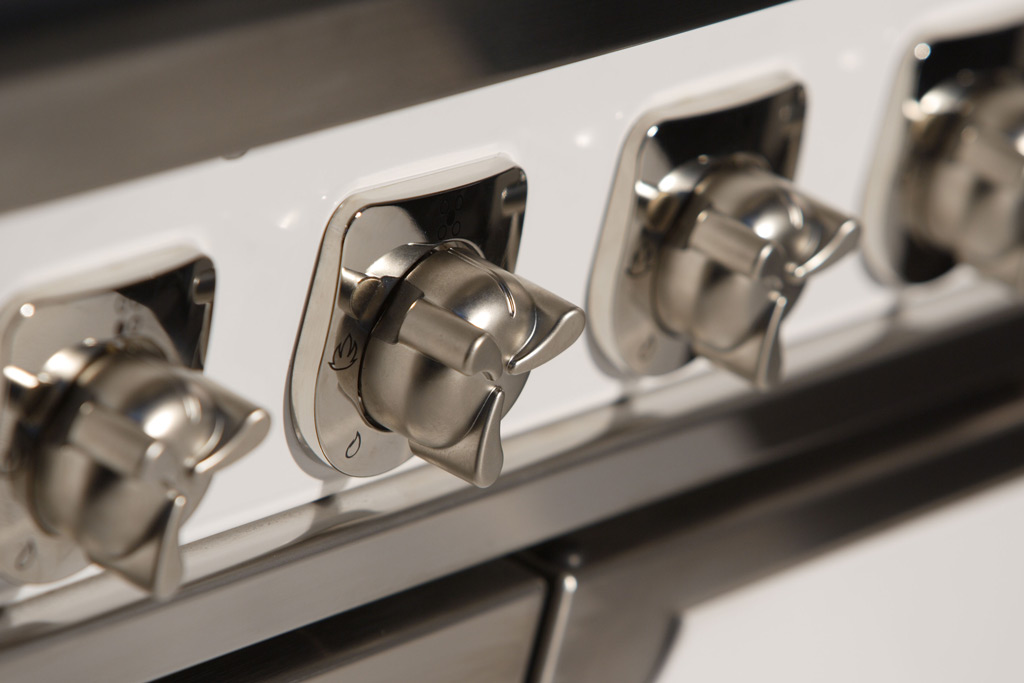 Edelstahl-Drehknöpfe eines modernen Gasherds in Nahaufnahme Nahaufnahme von mehreren Edelstahl-Drehknöpfen an einem weißen Gasherd