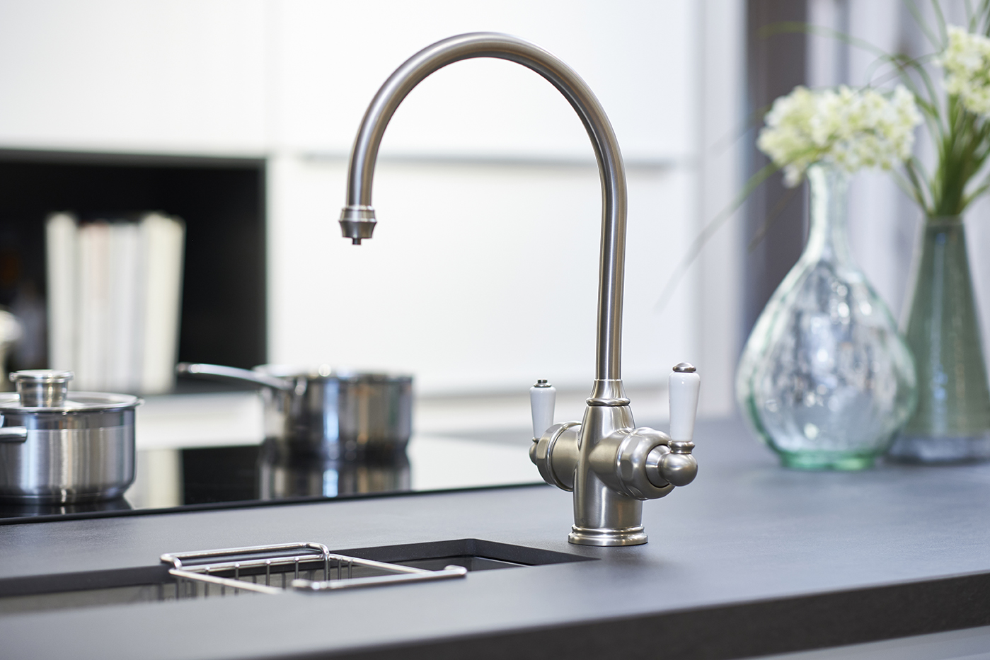 Elegante Küchenarmatur aus Edelstahl mit zwei Hebeln für modernes Küchendesign Nahaufnahme einer Edelstahl-Küchenarmatur mit zwei Hebeln an einem modernen Küchenspülbecken
