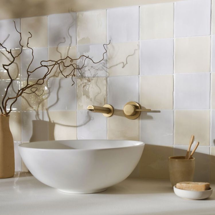 Weißes Aufsatzwaschbecken mit Wandarmatur in Messing