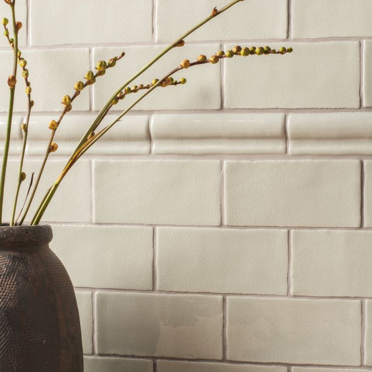 Wand mit cremefarbenen Metrofliesen, Bordüre und Vase