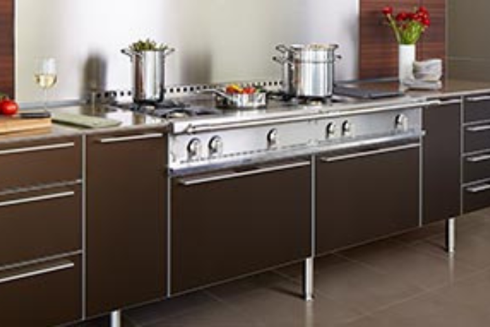 Moderne Edelstahlküche mit Kochfeld, Töpfen und stilvollen braunen Schränken Große, moderne Einbauküche mit braunen Unterschränken, Edelstahlkochfeld, mehreren Töpfen sowie Küchenutensilien und dekorativen Elementen wie Wein, Tomaten und Blumen