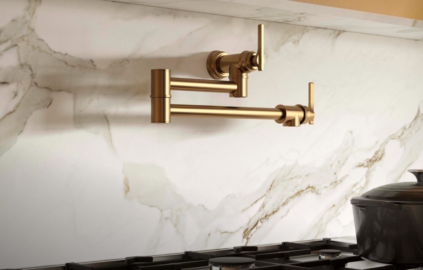 Goldene Wandarmatur zum Topffüllen aus gebürstetem Messing, zweiarmig klappbar, montiert über dem Kochfeld vor Marmor-Rückwand; praktische Küchenarmatur zum schnellen Befüllen von Töpfen am Herd