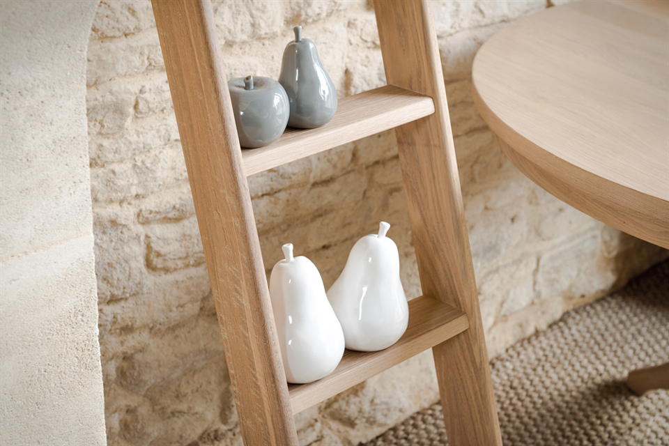 Dekorative Keramik-Birnen in Weiß und Grau auf Holzregal vor Steinwand Zwei weiße und zwei graue Keramik-Birnen als stilvolle Dekoration auf einem hellen Holzregal mit rustikaler Steinwand im Hintergrund