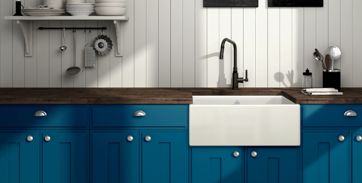 Moderne Landhausküche mit blauen Schränken, Holzarbeitsplatte und großer Keramikspüle Stilvolle Küche mit blauen Unterschränken, weißer Keramikspüle, brauner Holzarbeitsplatte und Wandregal mit Geschirr