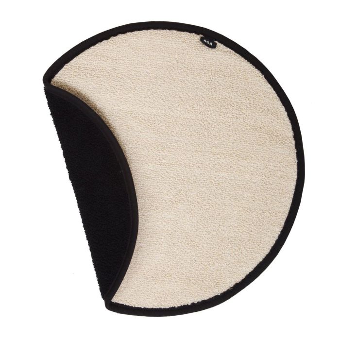 Runder Badteppich in Beige mit dunkel abgesetztem Rand, teilweise umgeschlagen und schwarze Unterseite sichtbar