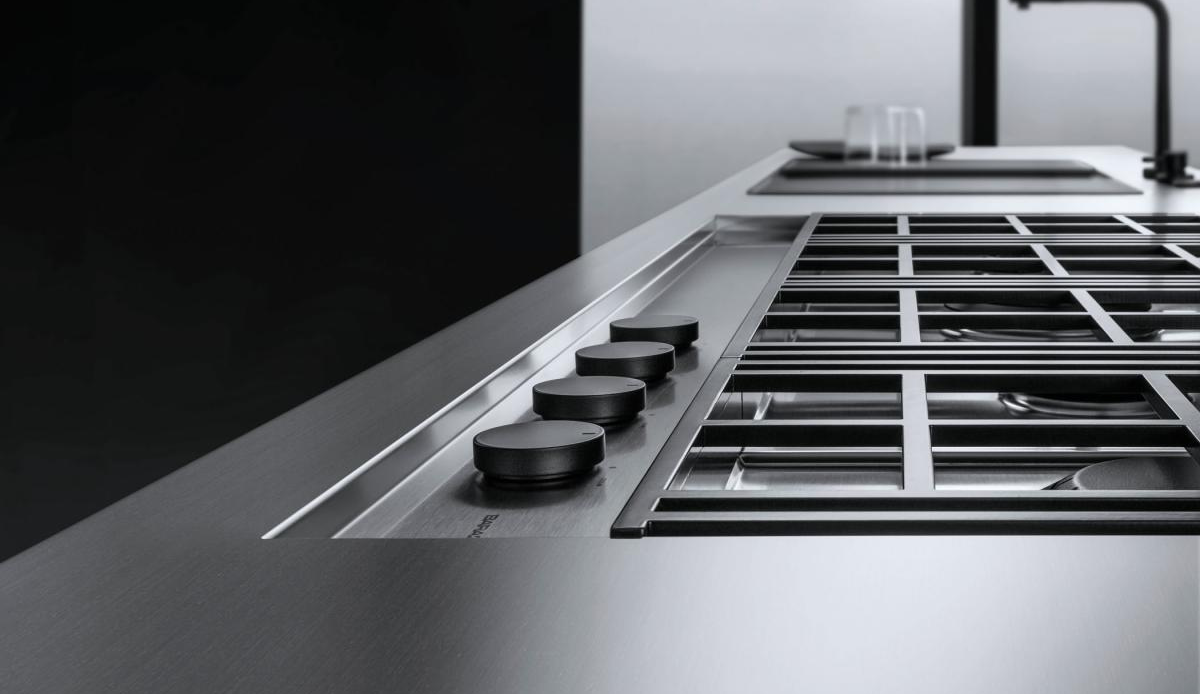 Modernes Gaskochfeld aus Edelstahl mit schwarzen Drehknöpfen für präzises Kochen Gaskochfeld aus Edelstahl mit vier schwarzen Drehknöpfen und robustem Gitterrost in moderner Küche