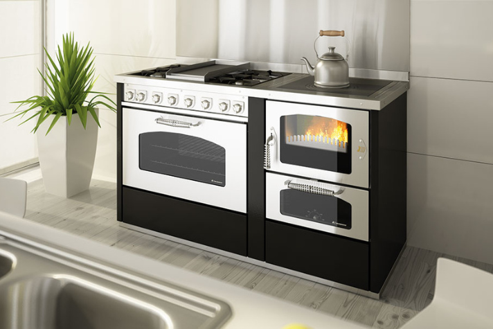 Moderner Küchenherd mit Gasherd, Backofen und Holzofen in stilvollem Küchendesign Küchenzeile mit modernem Herd, Gas-Kochfeldern, großem Backofen sowie integriertem Holzofen mit sichtbarem Feuer, daneben ein Wasserkocher auf der Herdplatte