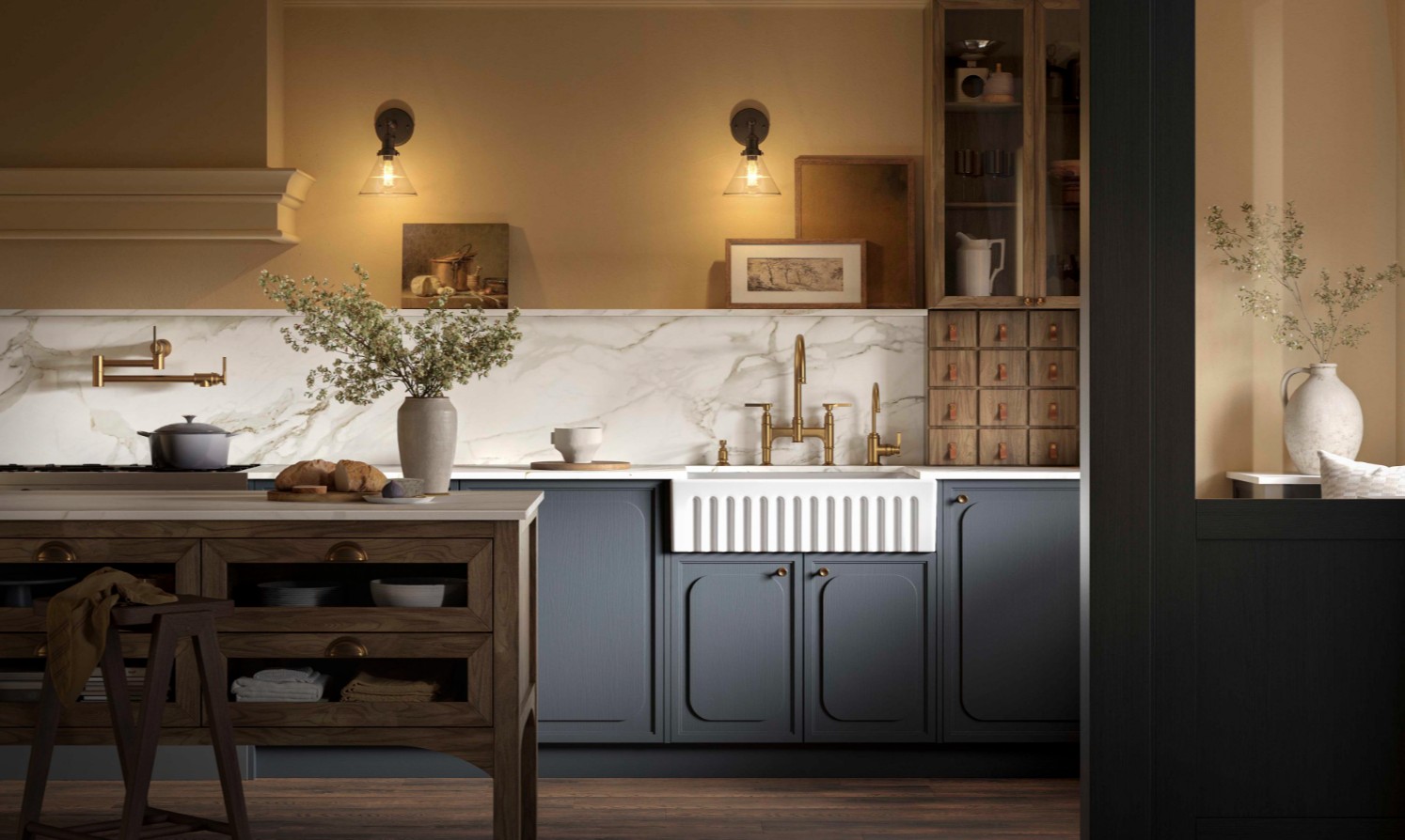 Weiße Keramik-Küchenspüle mit gerillter Schürzenfront, eingebaut in blau-graue Unterschränke; mit goldener Armatur und Marmor-Rückwand – elegantes Farmhouse Spülbecken für stilvolle Küchen