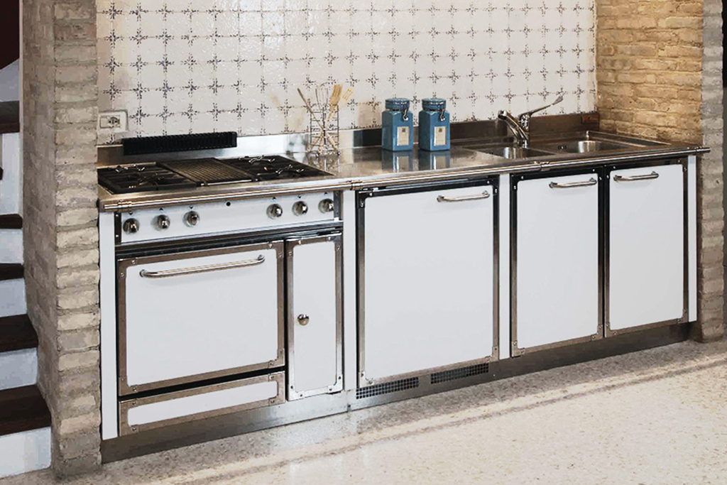 Moderne Küchenzeile mit Gasherd, Edelstahl-Spüle und weißen Fronten Küchenzeile mit Gasherd, Backofen, Edelstahl-Arbeitsplatte, Spüle, weißen Schranktüren und dekorativen Fliesen an der Wand