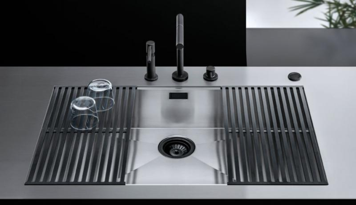 Moderne Edelstahlspüle mit Abtropfgittern und zwei Gläsern – stilvolles Küchenspülbecken mit Wasserhahn Edelstahlspüle mit schwarzem Wasserhahn, Seifenspender, Drehknopf und zwei auf Abtropfgittern stehenden Gläsern in moderner Küche