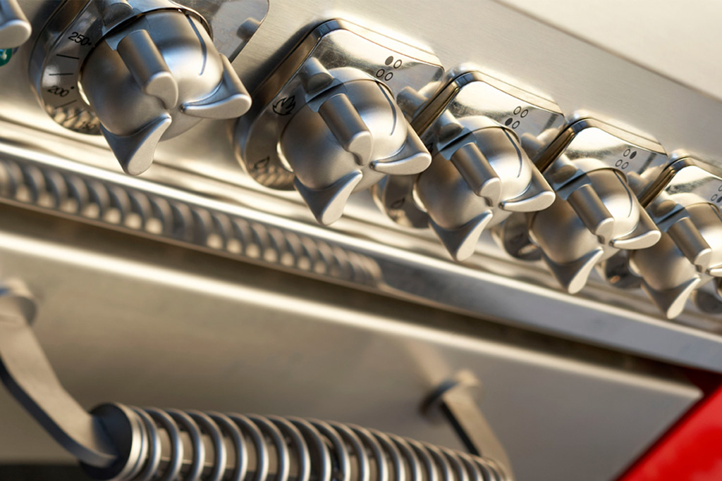 Edelstahl-Drehregler eines Gasgrills – Detailansicht für präzise Temperatureinstellung Nahaufnahme der Bedienknöpfe und Griff eines hochwertigen Gasgrills aus Edelstahl