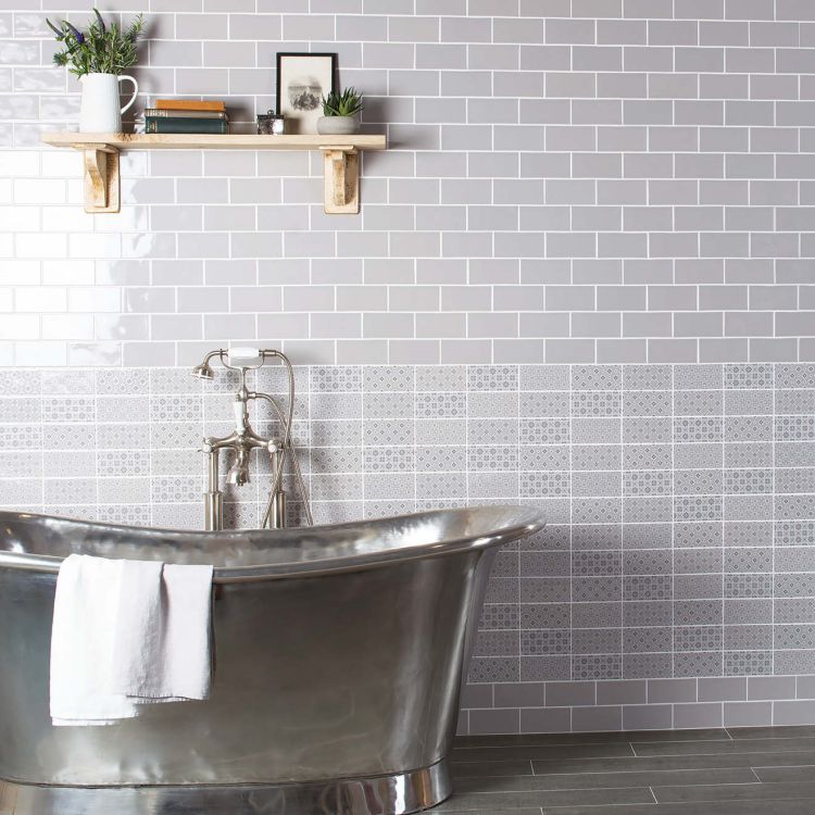 Freistehende Edelstahlwanne vor grauen Fliesen