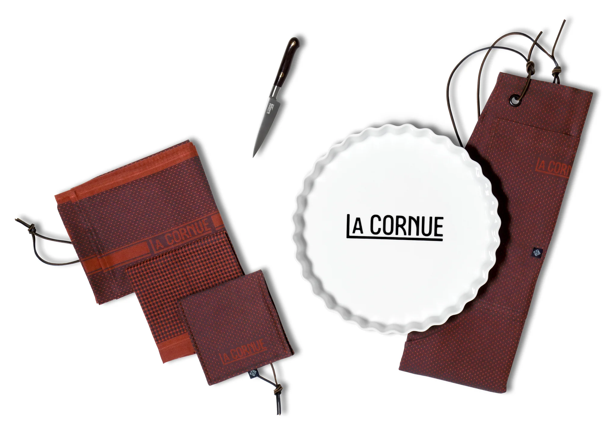 La Cornue Backset mit Keramik-Tarteform, Messer und edlen Küchentextilien La Cornue Backset bestehend aus einer weißen Keramik-Tarteform mit La Cornue Logo, einem Messer und braunen Küchentextilien mit Kordelzug