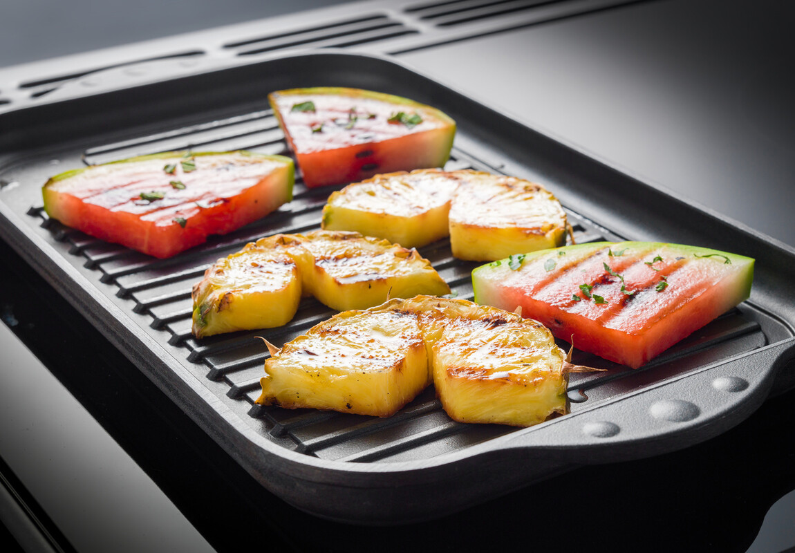 Gegrillte Ananas- und Wassermelonenstücke auf einer Grillplatte – fruchtige Grillideen für den Sommer Gegrillte Ananas- und Wassermelonenstücke liegen nebeneinander auf einer Grillplatte und sorgen für eine leckere, fruchtige Beilage zum Grillen