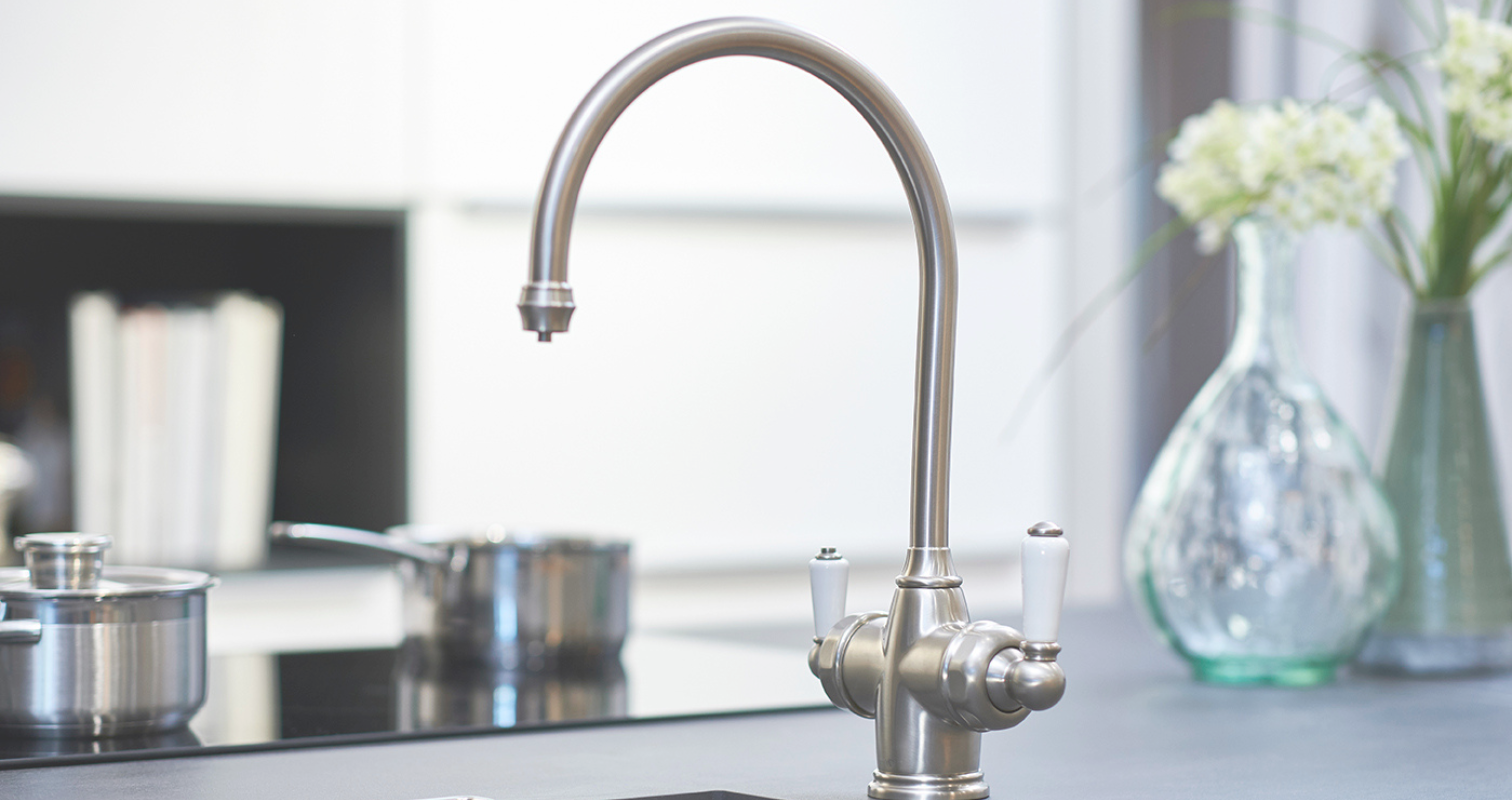 Elegante Küchenarmatur aus Edelstahl mit traditionellem Design für moderne Küchen Nahaufnahme einer eleganten Küchenarmatur aus Edelstahl im klassischen Stil, installiert auf einer modernen Küchenarbeitsplatte