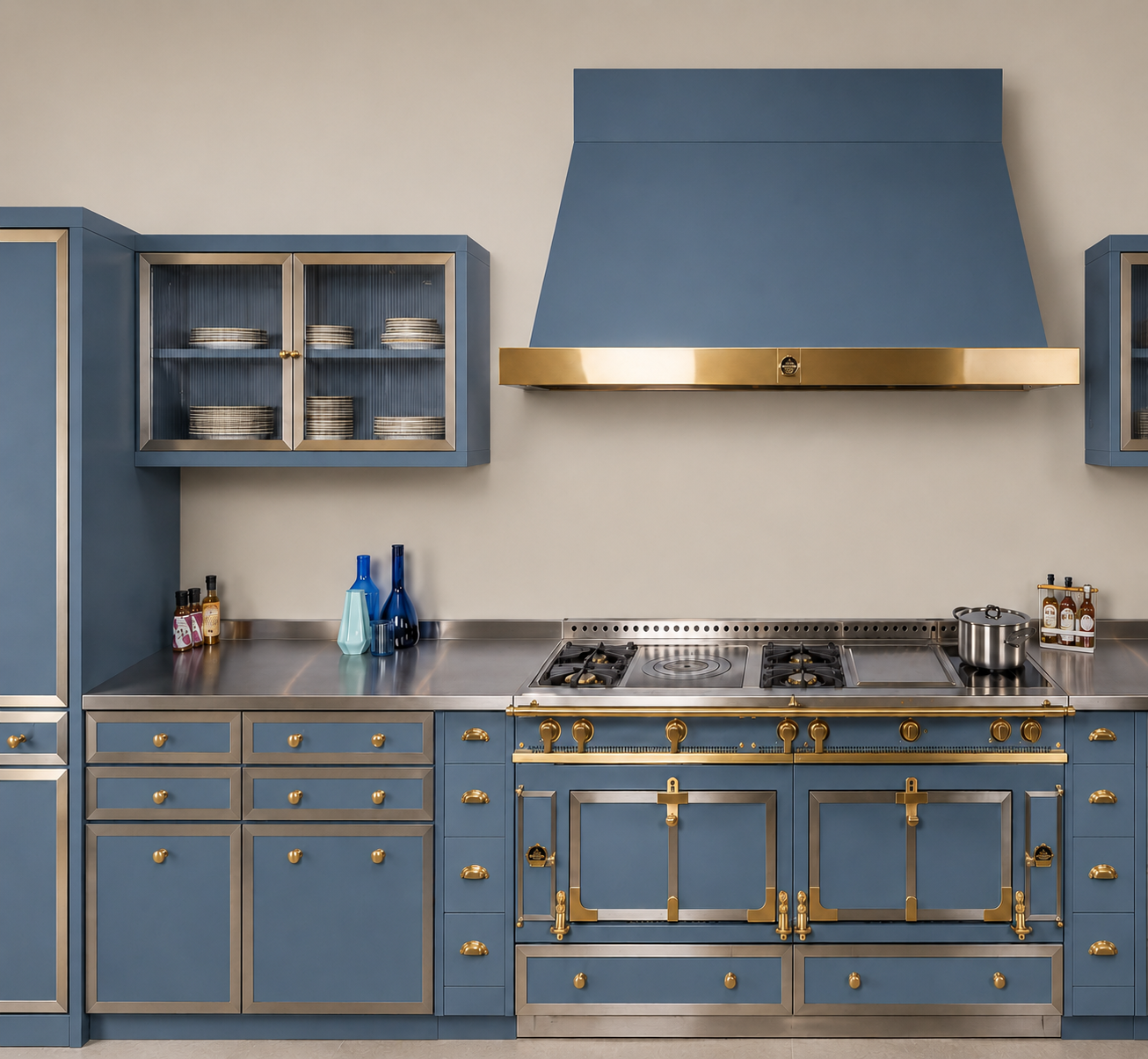 Design-Küchenzeile mit blauem Profi-Gasherd, goldenen Beschlägen, Bratplatte und zwei Brennern, passender Dunstabzugshaube sowie Edelstahl-Arbeitsflächen – hochwertiges Kochzentrum für Premiumküchen