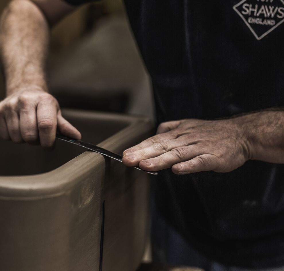 Handwerker glättet Kante an Keramikspülbecken