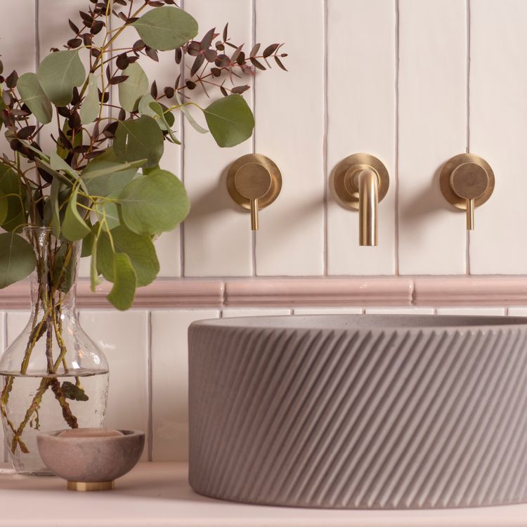 Rundes Betonwaschbecken mit wandmontierter Messing-Armatur