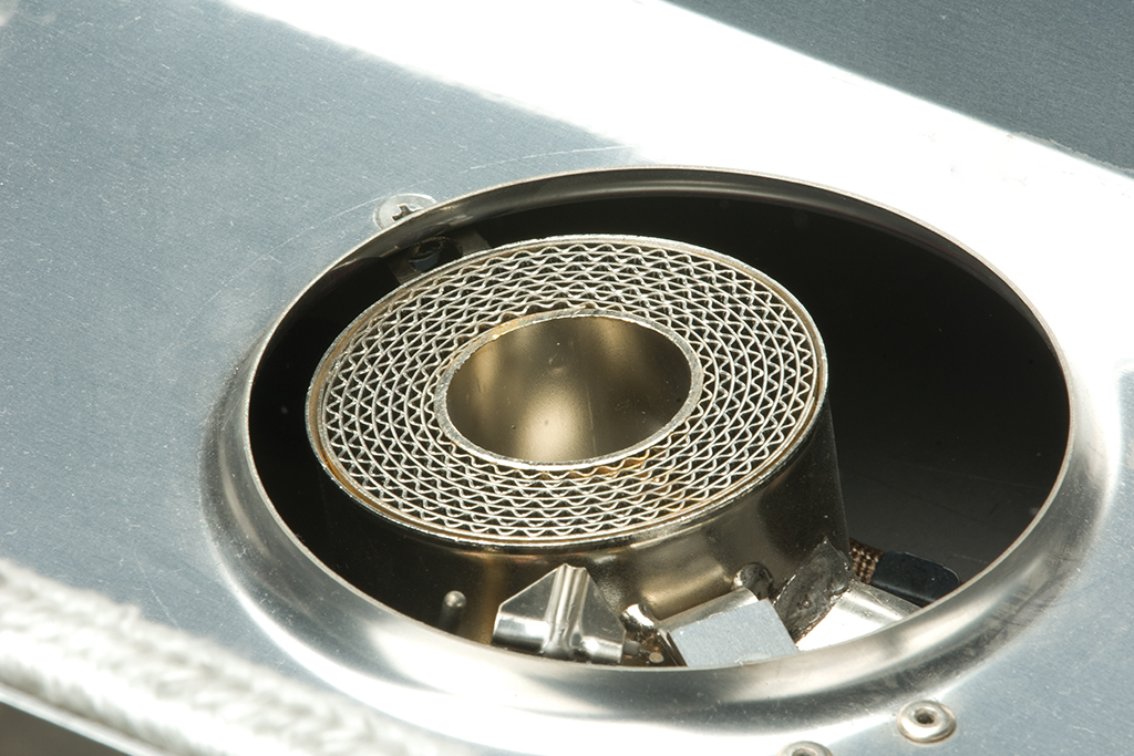 Nahaufnahme eines Katalysators aus Metall in einem technischen Gerät Detailansicht eines Metallkatalysators in einem technischen Gerät, Fokus auf das wabenförmige Innenteil