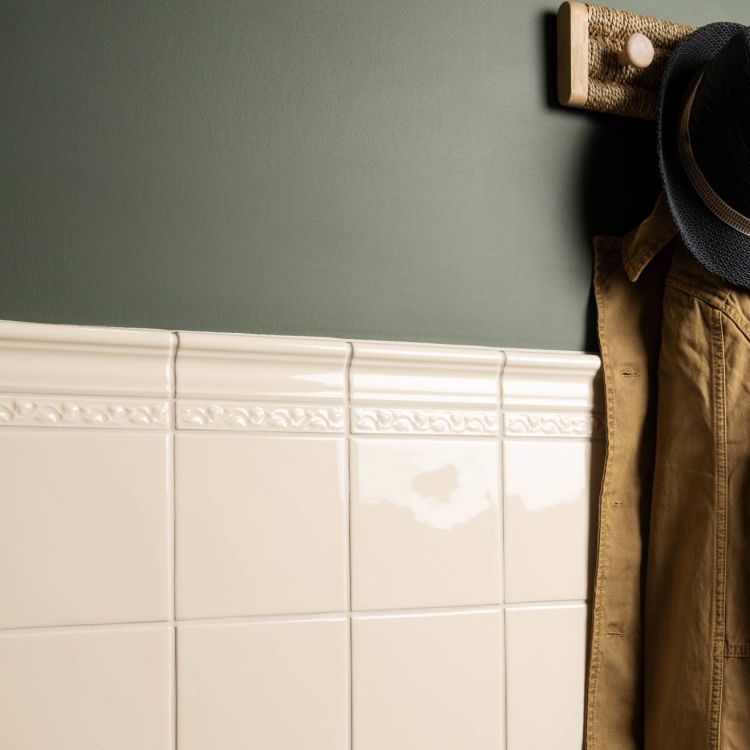 Glänzende cremefarbene Wandfliesen mit Zierbordüre