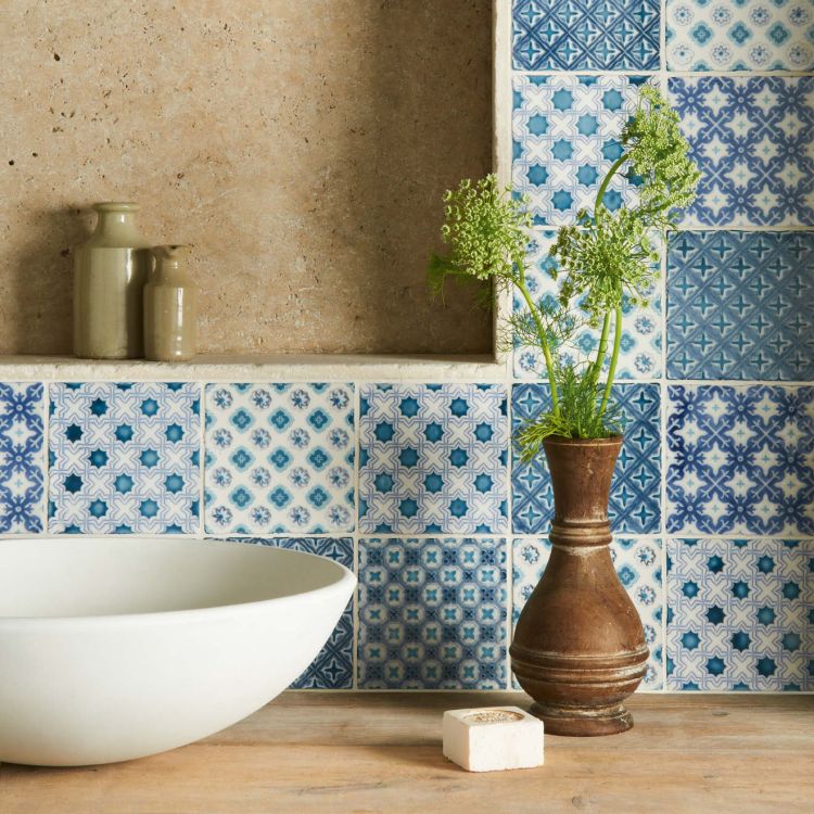 Waschbecken vor blau gemusterten Keramikfliesen mit Vase