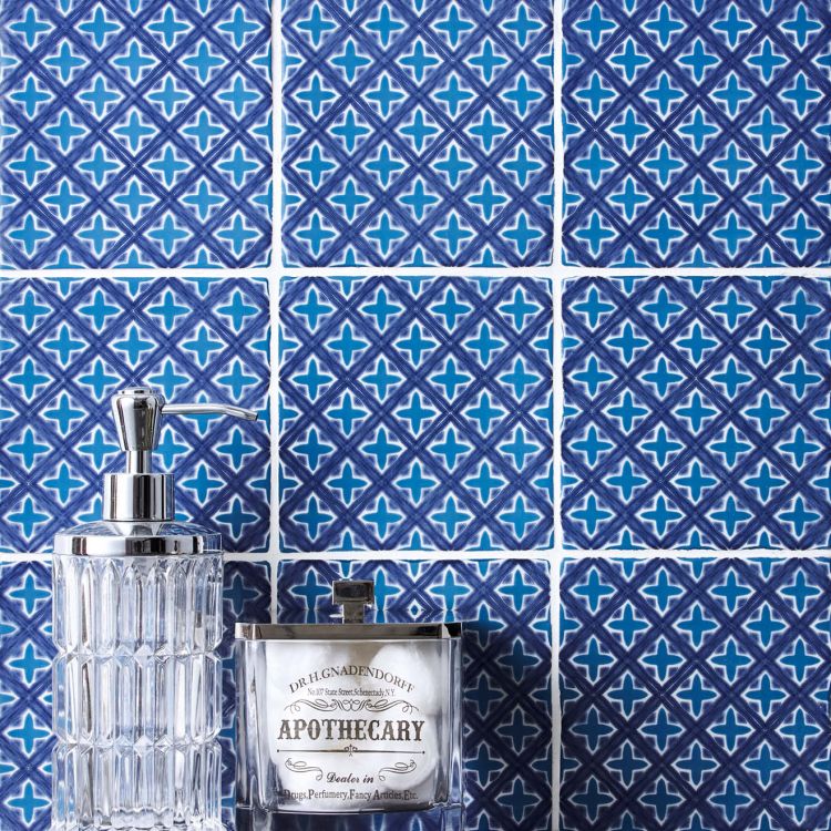 Blaue Keramikfliesen, Seifenspender und Duftkerze