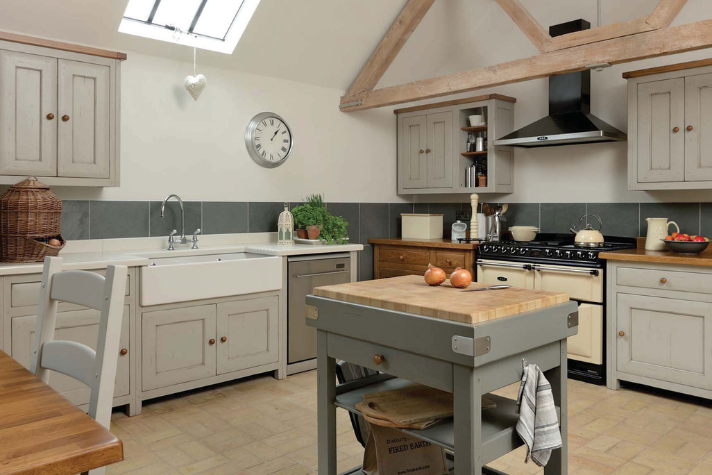 Gemütliche Landhausküche mit Holzelementen, moderner Ausstattung und Kücheninsel Helle Landhausküche mit sichtbaren Holzbalken, Spülbecken unter Fenster, Küchenblock, Holzmöbeln und moderner Küchentechnik