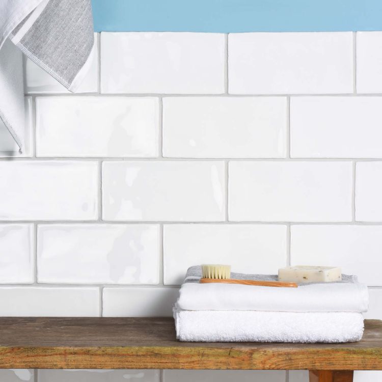 Weiße Metrofliesen, Handtuch, Seife und Bürste im Bad