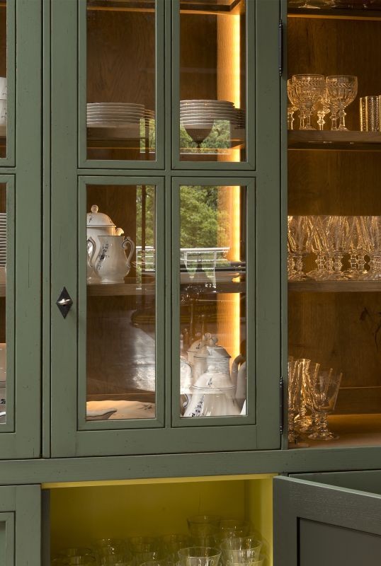 Einblick in einen stilvollen Geschirrschrank mit Glastüren, der Porzellan und Kristallgläser präsentiert.