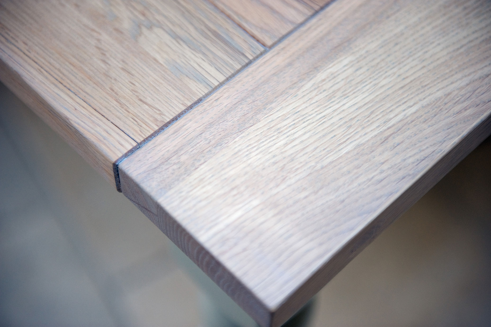 Detailansicht einer Tischkante aus hellem Massivholz Nahaufnahme einer Ecke eines Tisches aus hellem Holz mit sichtbarer Maserung