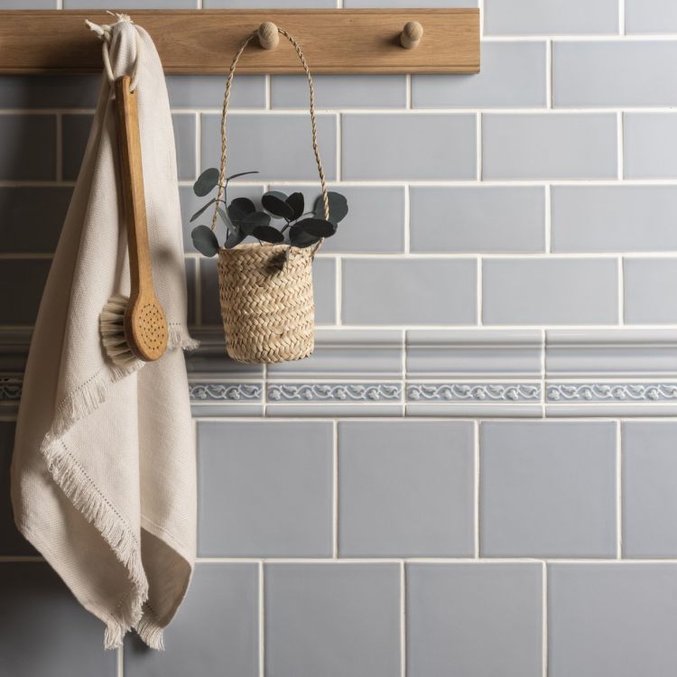 Bad mit grauen Metrofliesen, Holzleiste, Handtuch, Bürste