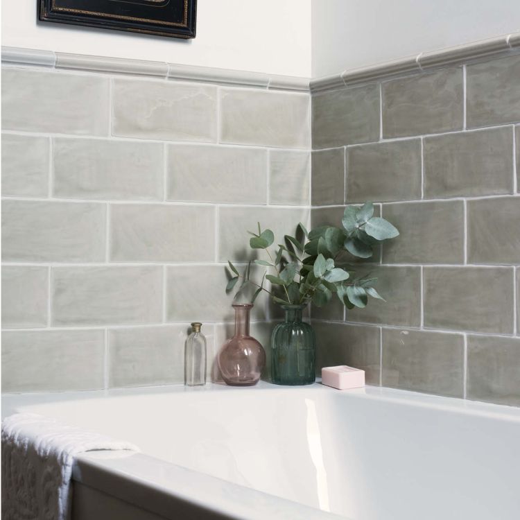 Badewanne mit grauen Metrofliesen und Eukalyptus