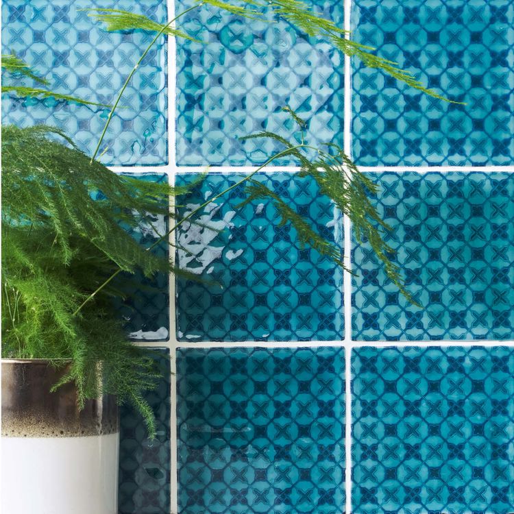 Türkise Keramikfliesen mit Kreuzmuster und Pflanze