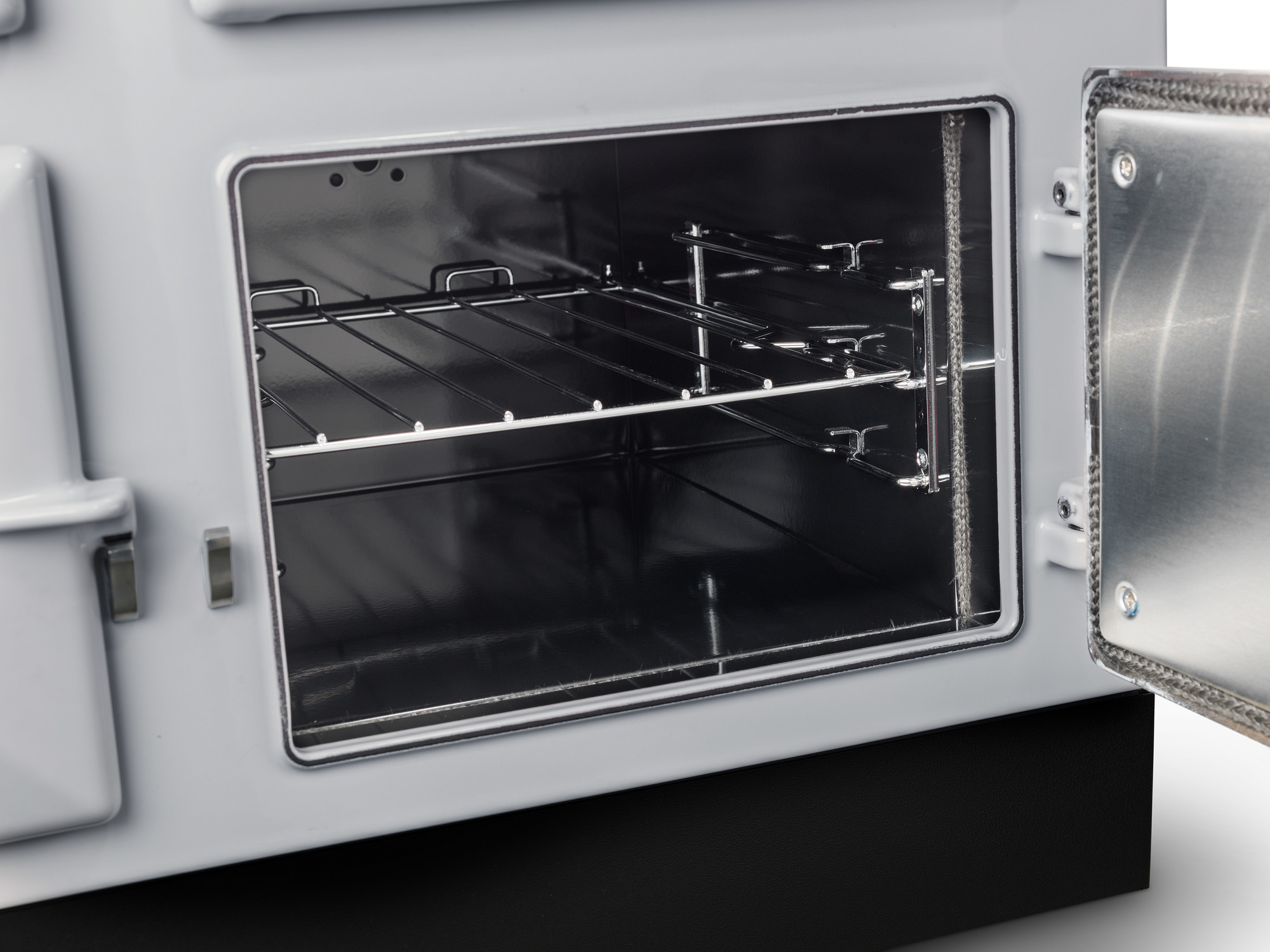 Geöffneter Backofen mit Gitterrost in moderner Edelstahl-Optik Innenansicht eines geöffneten Backofens mit Gitterrost und geöffneter Tür, geeignet für die Zubereitung von Speisen