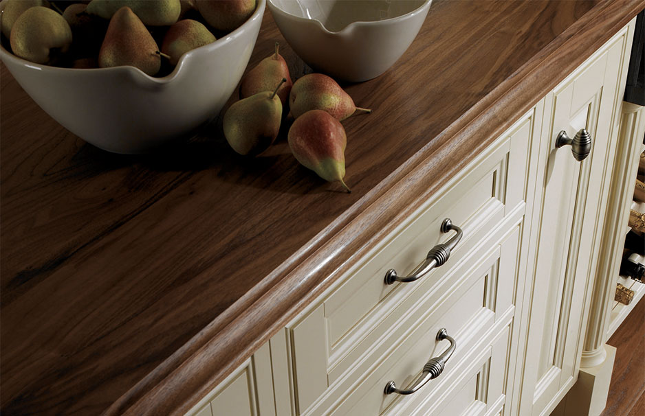 Küchenkommode mit edler Holzarbeitsplatte und Schalen mit Birnen Detailansicht einer hellen Küchenkommode mit dunkler Holzarbeitsplatte, darauf Schalen mit Birnen