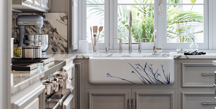 Moderne Landhausküche mit großer Keramikspüle und Marmordetails Helle Küche mit großer Keramikspüle mit blauem Blumenmuster, Marmorarbeitsplatte und Blick auf grünen Garten durch Fenster
