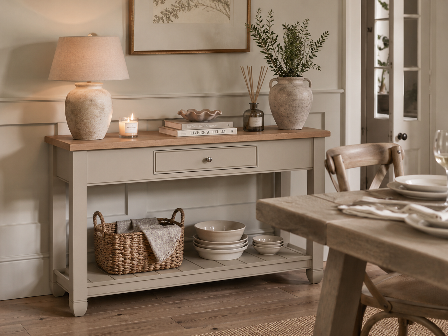 Beiger Konsolentisch mit Holzplatte, Schublade und Bodenablage, dekoriert mit Keramiklampe, Vase, Duftstäbchen und Korb; ideale Anrichte im Esszimmer mit Stauraum für Geschirr und Accessoires.