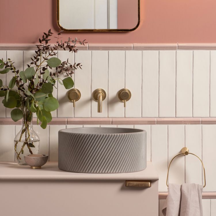 Modernes Bad mit grauem Becken und Messingarmatur