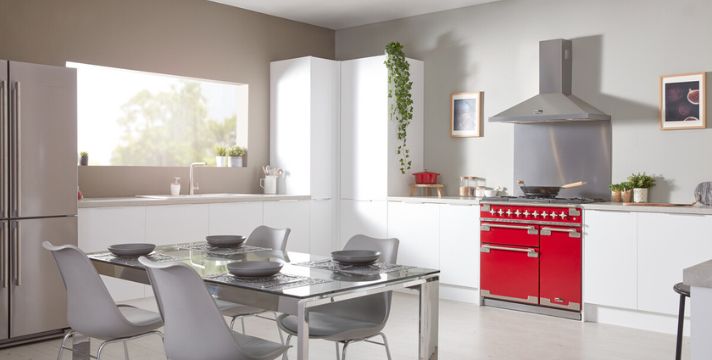 Helle weiße Küche mit rotem Standherd und Esstisch
