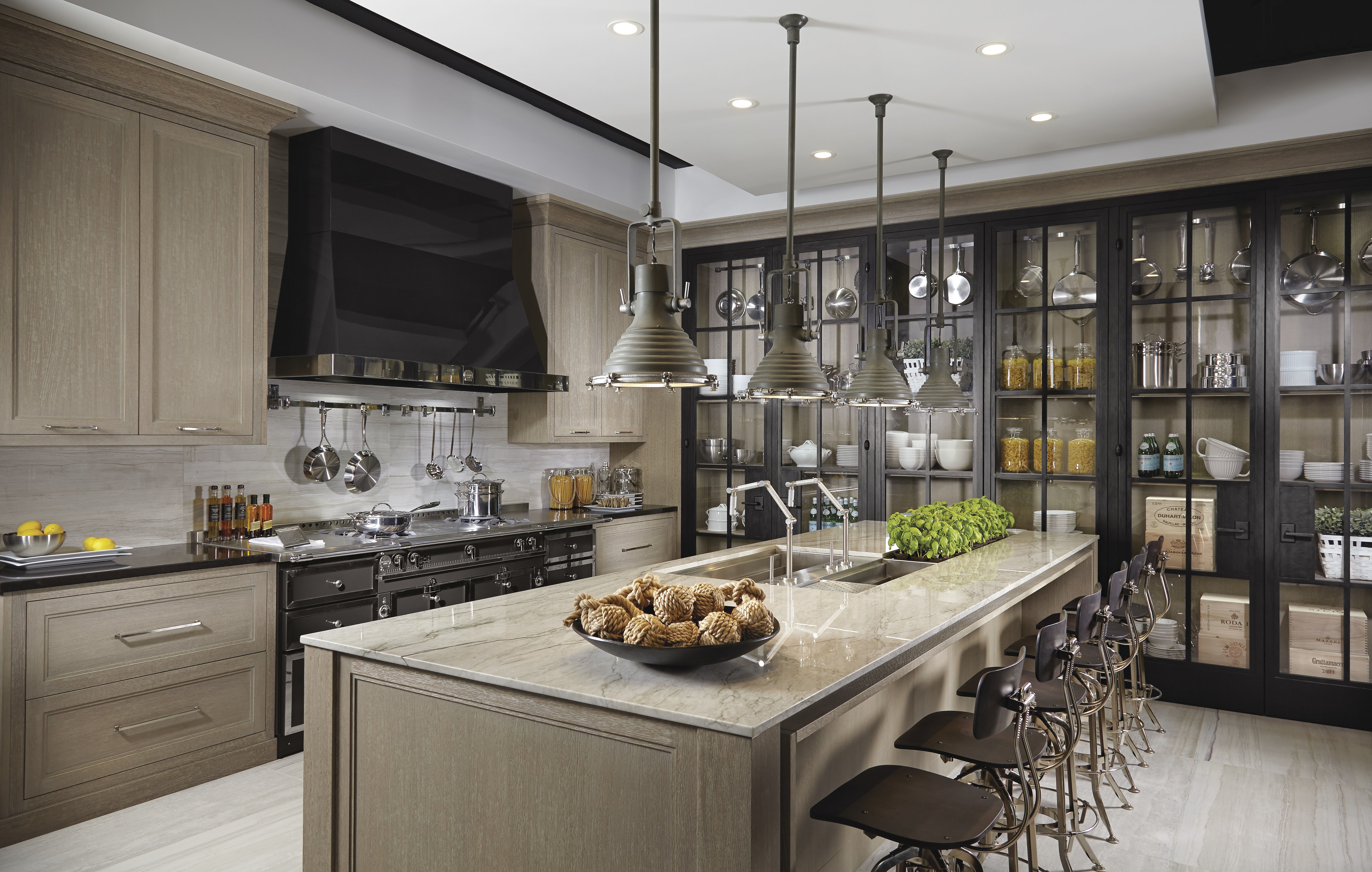 Moderne luxuriöse Küche mit Kücheninsel, Barhockern und hochwertiger Ausstattung Große moderne Küche mit stilvoller Kochinsel, Barhockern, Hängelampen, schwarzen Küchengeräten, Vorratsregalen sowie edler Marmorarbeitsplatte und frischen Kräutern als Dekoration