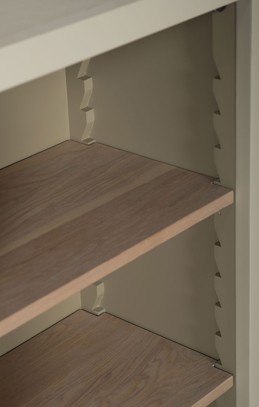 Detailansicht eines Regals mit höhenverstellbaren Einlegeböden aus Holz und seitlichen, gezackten Halterungen Nahaufnahme eines Regals zeigt Holz-Einlegeböden und verstellbare, gezackte seitliche Halterungen für flexible Höhenanpassung