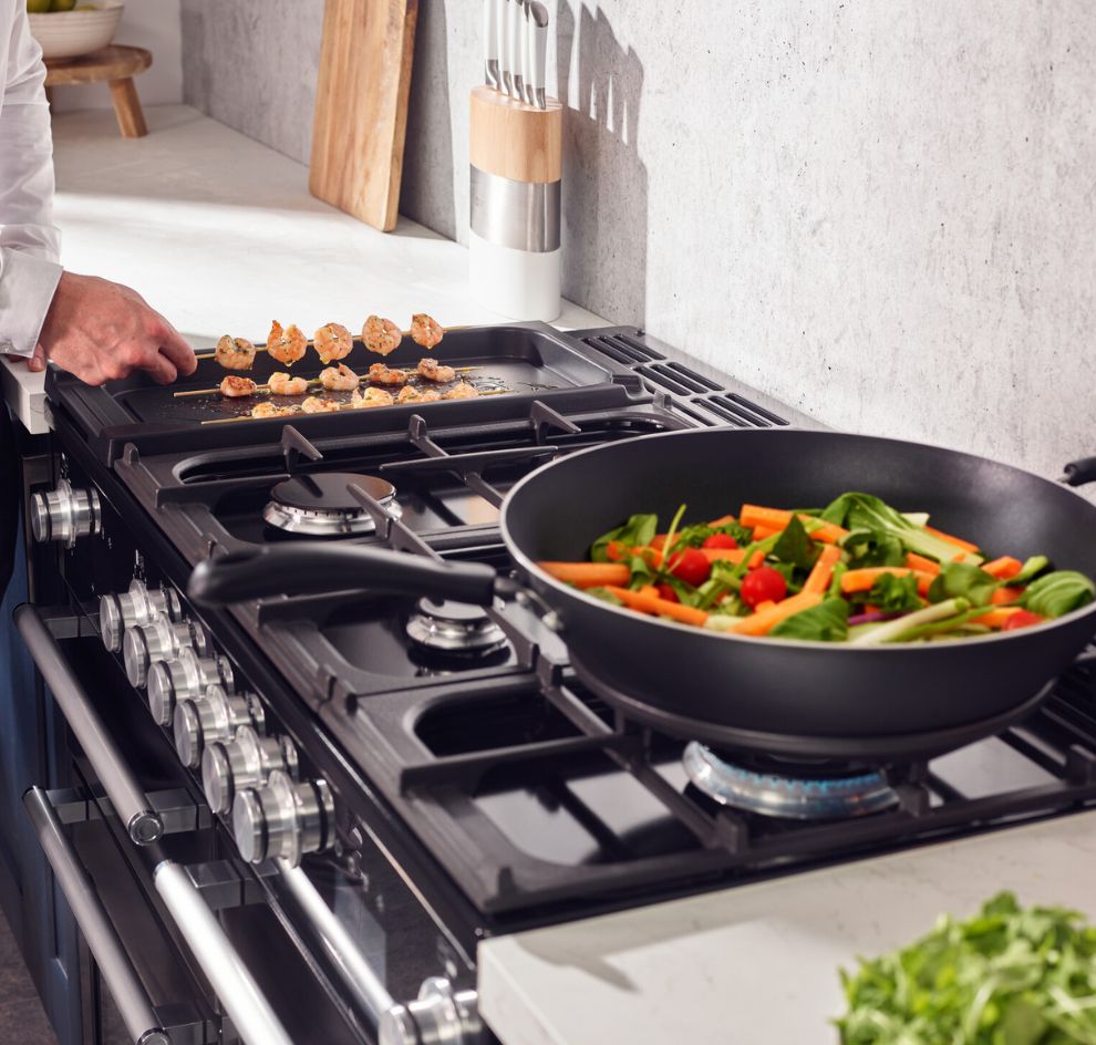 Gaskochfeld mit Gemüsepfanne und Grillspießen