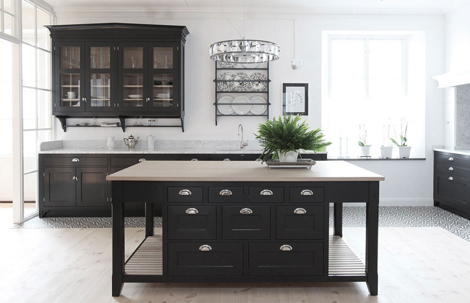Moderne schwarze Landhausküche mit Kücheninsel, Arbeitsplatte aus Holz und elegantem Stauraum Großzügige, helle Küche im Landhausstil mit schwarzen Schränken, Kücheninsel, Holzarbeitsplatte und Dekorationen wie Pflanzen und Hängelampen