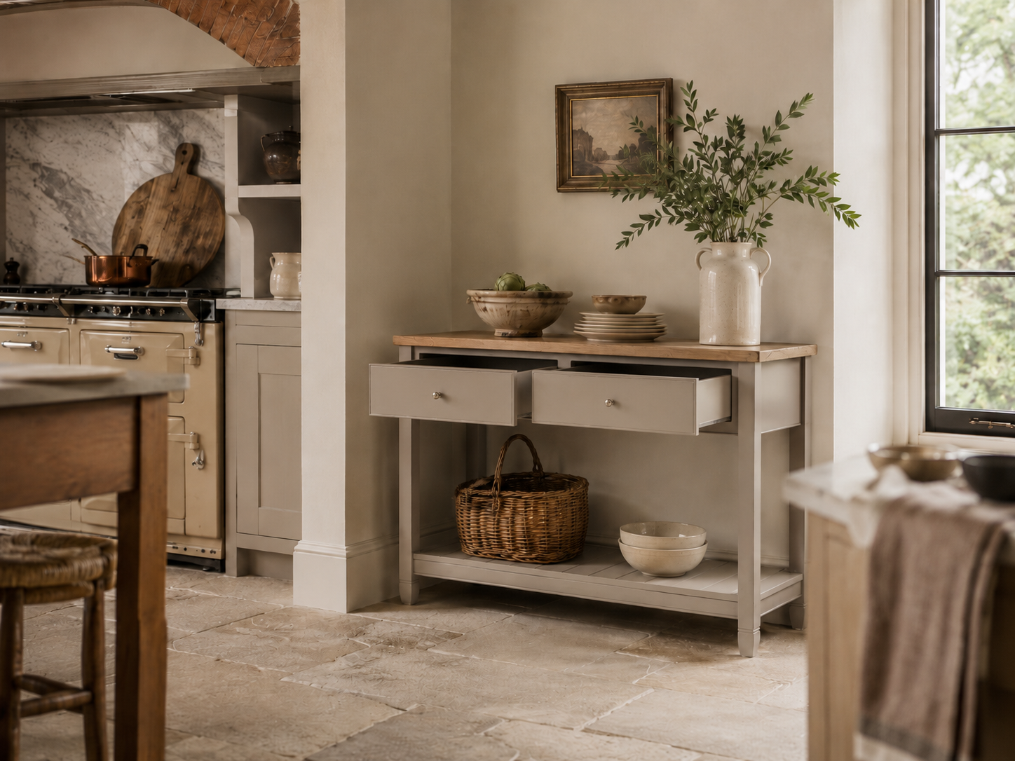 Graues Küchen-Sideboard im Landhausstil mit massiver Eichenplatte, zwei Schubladen und unterer Ablage, dekoriert mit Keramikschalen, Korb und Vase mit Zweigen