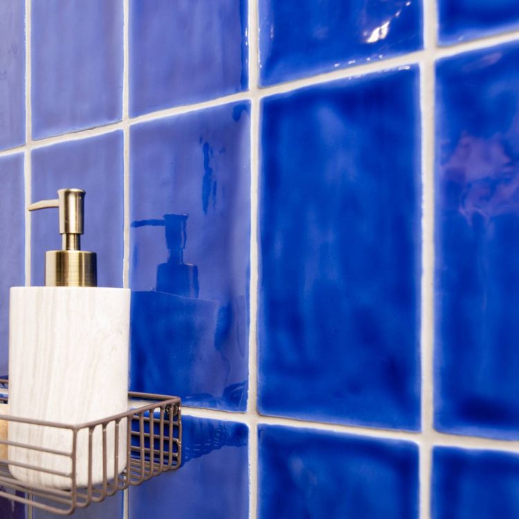 Blaue Keramikfliesen glänzend, Badwand mit Spender