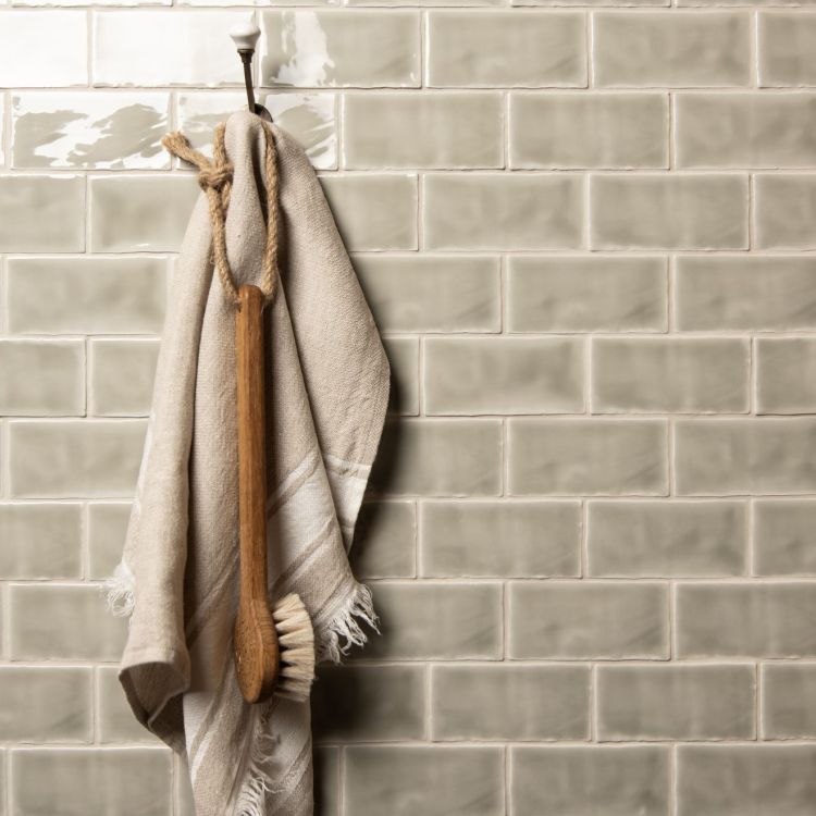 Beiges Handtuch mit Badebürste an Wandhaken