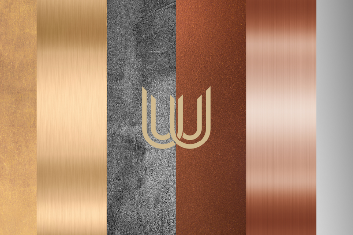 Materialmix mit strukturierten Metall- und Steinoberflächen, modernes abstraktes Design Abbildung zeigt verschiedene nebeneinander angeordnete Oberflächen in Gold, gebürstetem Messing, Beton, rostigem Metall, Kupfer und Silber mit stilisiertem Logo in der Mitte