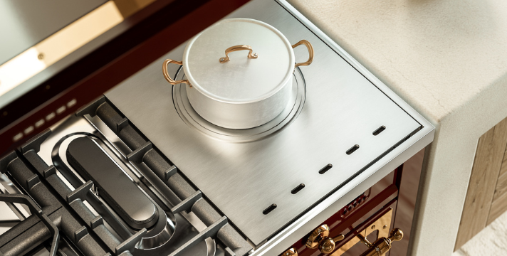 Hochwertiger Gasherd mit Edelstahldeck und Kochtopf in einer modernen Küche Detailaufnahme eines modernen Gasherds mit Metalltopf auf der Herdplatte und eleganten Bedienelementen