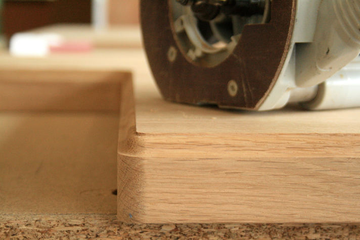 Fräse bearbeitet Holzkante für sauberes Finish bei Holzarbeiten Detailaufnahme einer Fräse, die eine Holzkante abrundet, zur professionellen Bearbeitung von Holzoberflächen